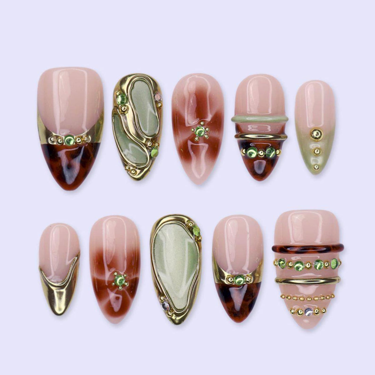 Ten almond press-on nails laid in two rows on a lilac background. Glossy sheer nude bases with brown tortoiseshell swirls, sage green jade-look panels rimmed in raised gold, gold chrome tips, and rows of tiny green gems.