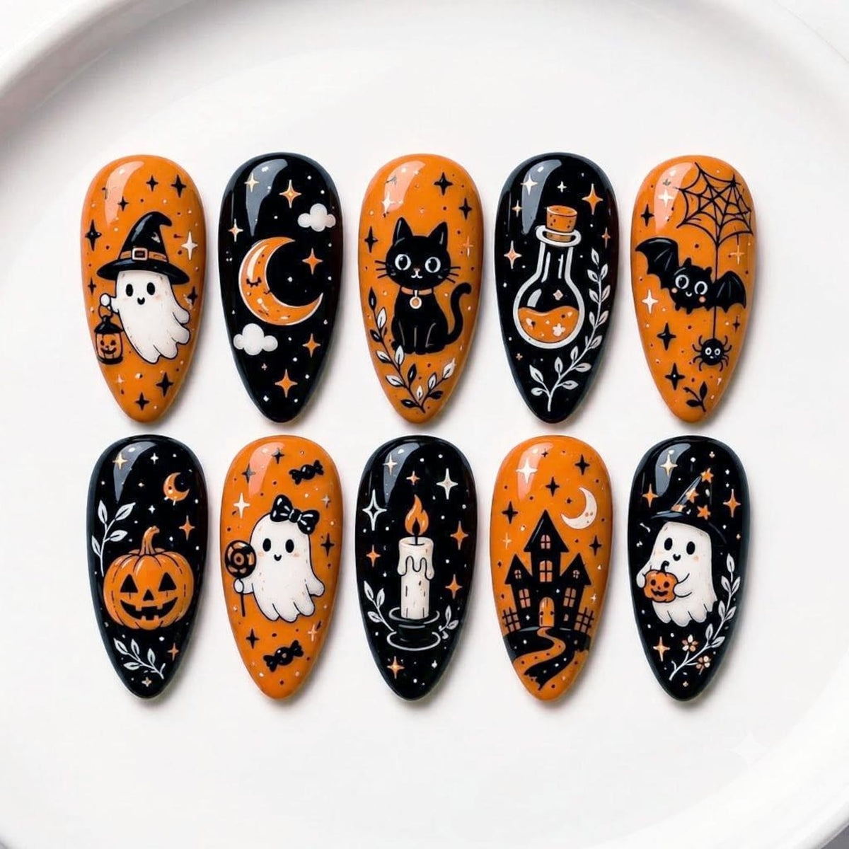 Ten almond-shaped press-on nails featuring Halloween-themed illustrations in black and orange. Designs include a ghost with a lantern, a crescent moon, a black cat, a potion bottle, a bat, a pumpkin, a ghost with a bow, a candle, a house, and a ghost