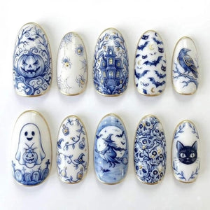 A set of ten oval-shaped press-on nails featuring blue and white illustrations of Halloween themes including a jack-o'-lantern, spider webs, a haunted house, bats, a raven, a ghost, potion bottles, a witch, skulls, and a black cat.