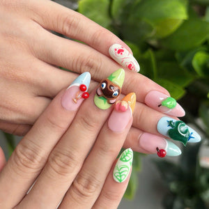 Cozy game inspired press on nails with cute animal, fruit and leaf details in pastel pink, green, blue and yellow on glossy almond shaped nails