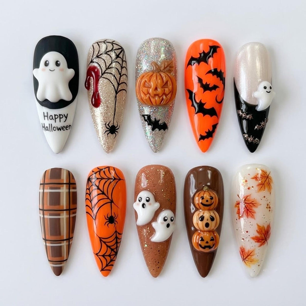 Ten almond-shaped press-on nails featuring Halloween designs including a white ghost with the text Happy Halloween, spider webs, a 3D pumpkin, black bats on orange, a small ghost, brown plaid, a spider, two ghosts, three pumpkins, and leaves.