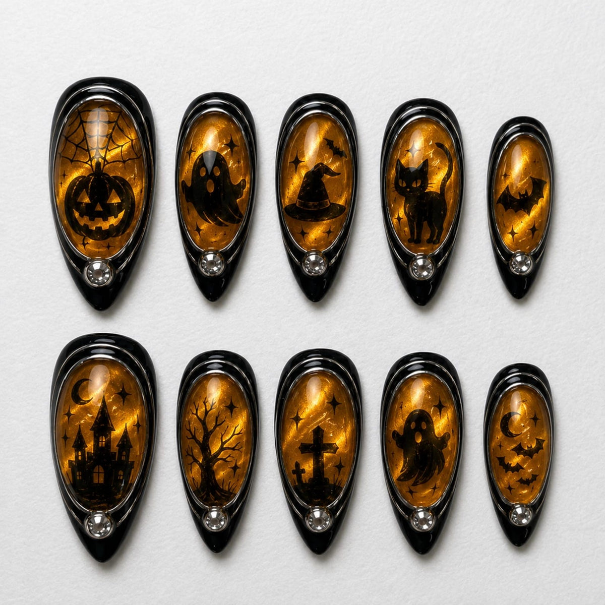 A set of ten almond-shaped press-on nails featuring a glossy amber cat-eye effect base with black Halloween-themed silhouettes including a pumpkin, ghost, witch hat, cat, bats, haunted house, tree, and cross, accented with small rhinestones.
