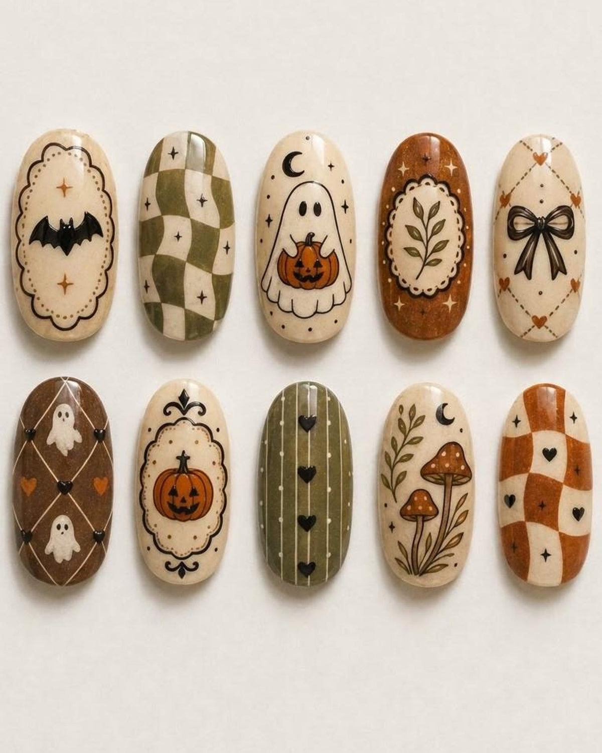 A set of ten oval-shaped press-on nails featuring various designs including a black bat, green and white checkered patterns, a ghost holding a pumpkin, a leafy branch, a black bow, small white ghosts, a pumpkin, vertical stripes, mushrooms, and heart