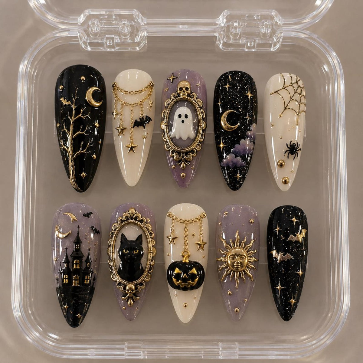 A set of ten almond-shaped press-on nails in a clear plastic case. The designs feature black, white, and lavender backgrounds with gold metallic accents including moons, stars, a haunted house, a black cat, a ghost, a pumpkin, and a sun.