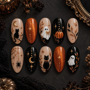 A set of ten almond-shaped press-on nails featuring Halloween designs. The nails display black cats, white ghosts, orange glitter, gold moons, stars, spiderwebs, and pumpkins on nude and black backgrounds with raised gold accents.