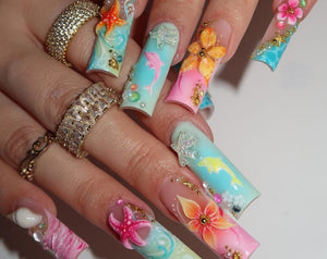 Long square-shaped artificial nails featuring a tropical theme with gradient blue and pink backgrounds. The nail art includes three-dimensional starfish, dolphins, and floral designs, accented with sm
